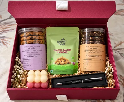 The Sweet & Sophisticated Box open, showing two jars of cookies, Paper Boat cashews, a bubble candle and a Thank You pen in a red gift box